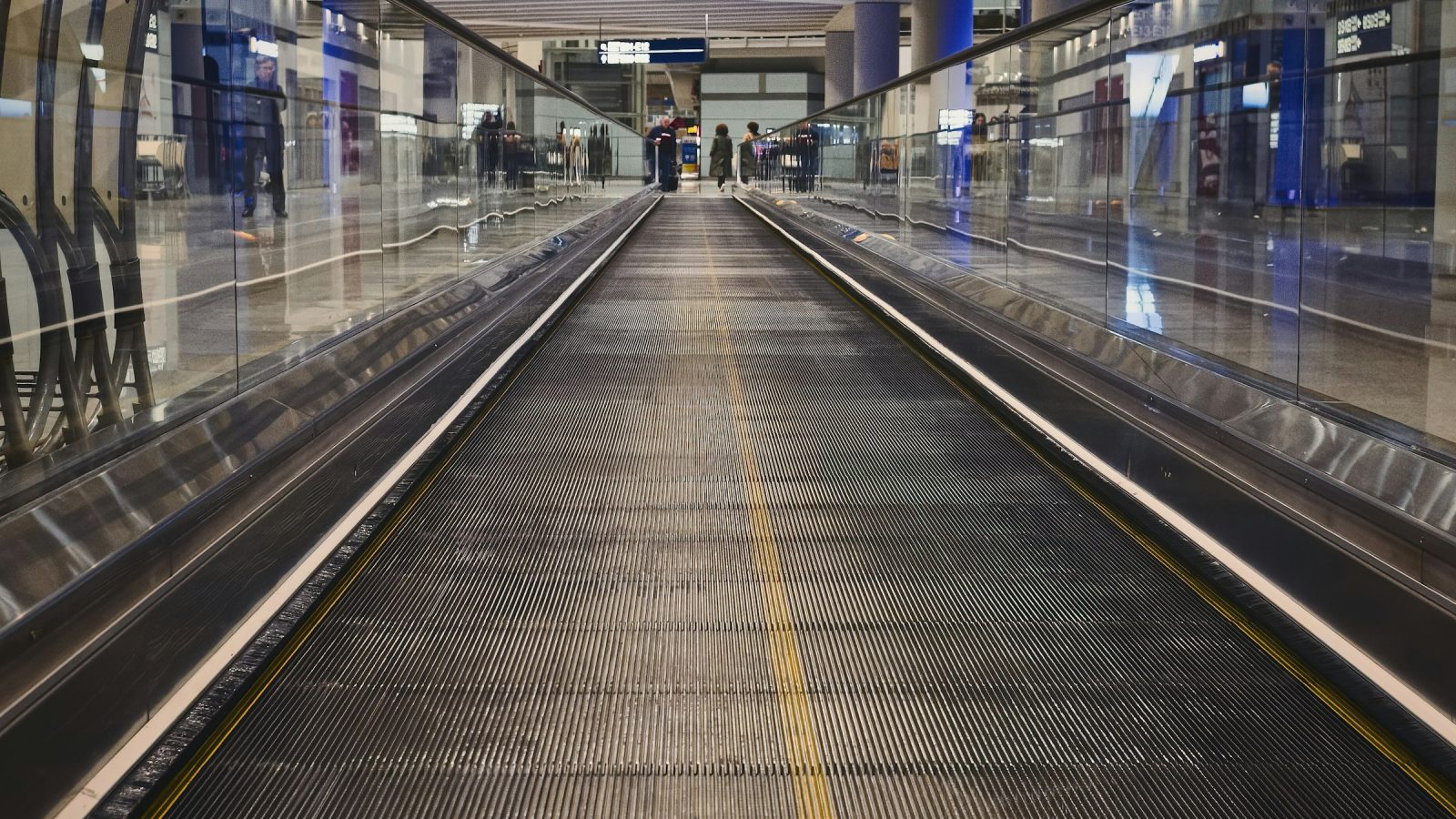 Travelers walking through a modern airport terminal, reflecting 2026 travel trends