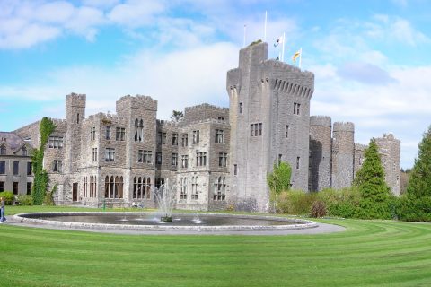 Ashford Castle, a five-star castle hotel in Ireland, seen across its lakeside grounds