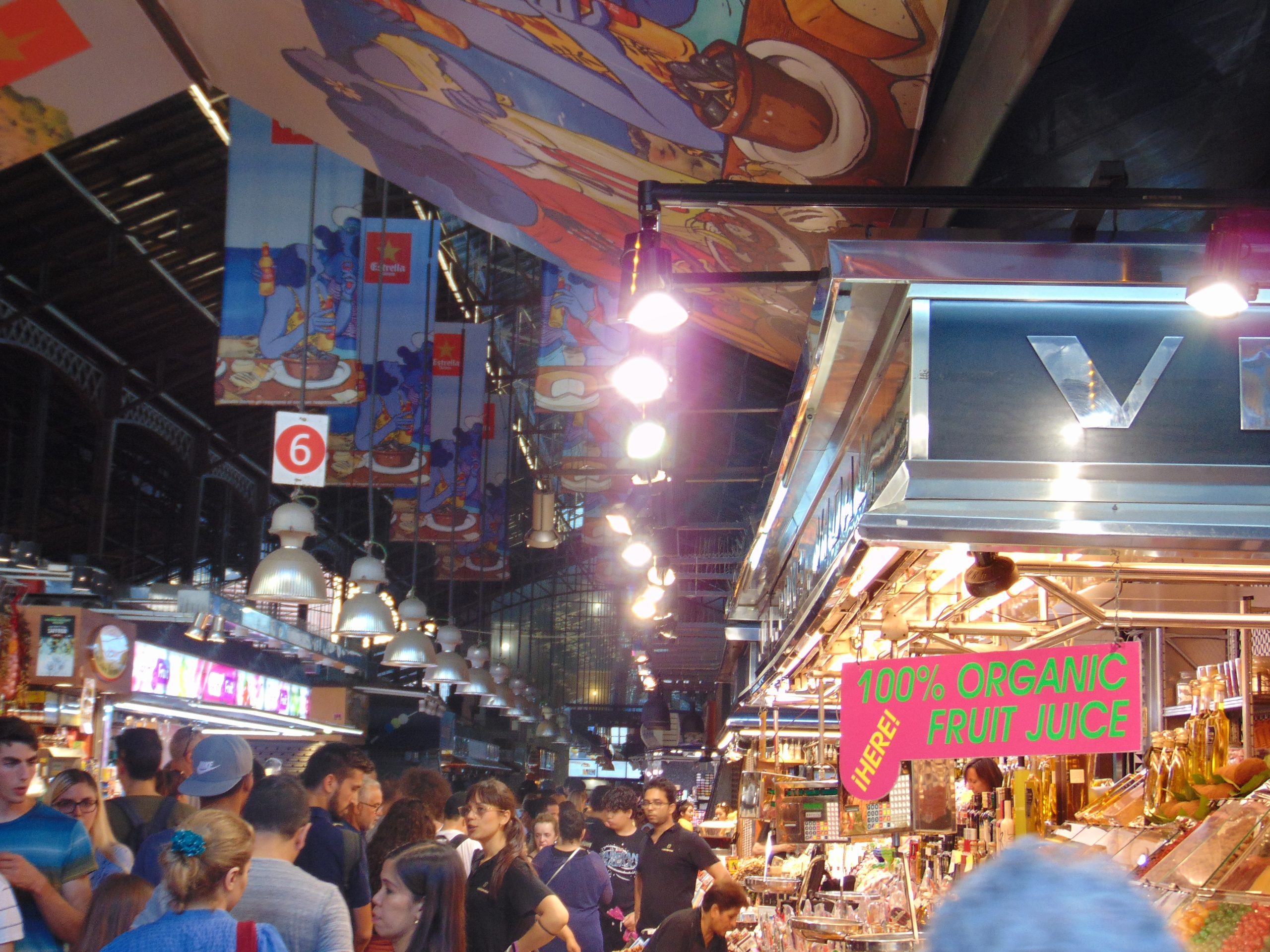 Vendor stalls and shoppers inside Mercat de la Boqueria food market in Barcelona