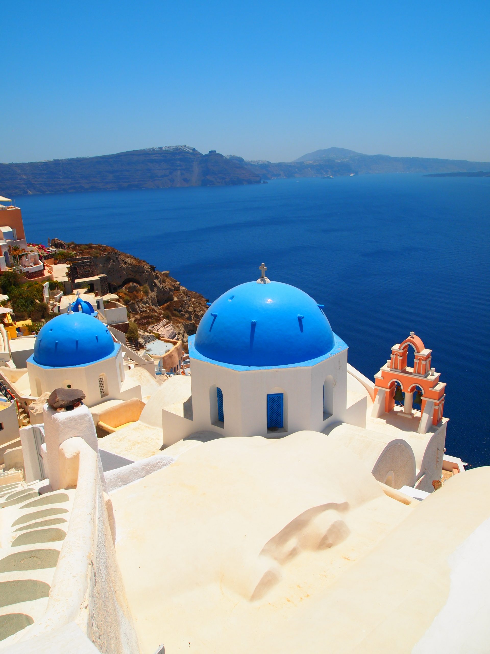 Iconic blue domes of Oia's churches overlooking the caldera, a highlight of any Santorini travel guide