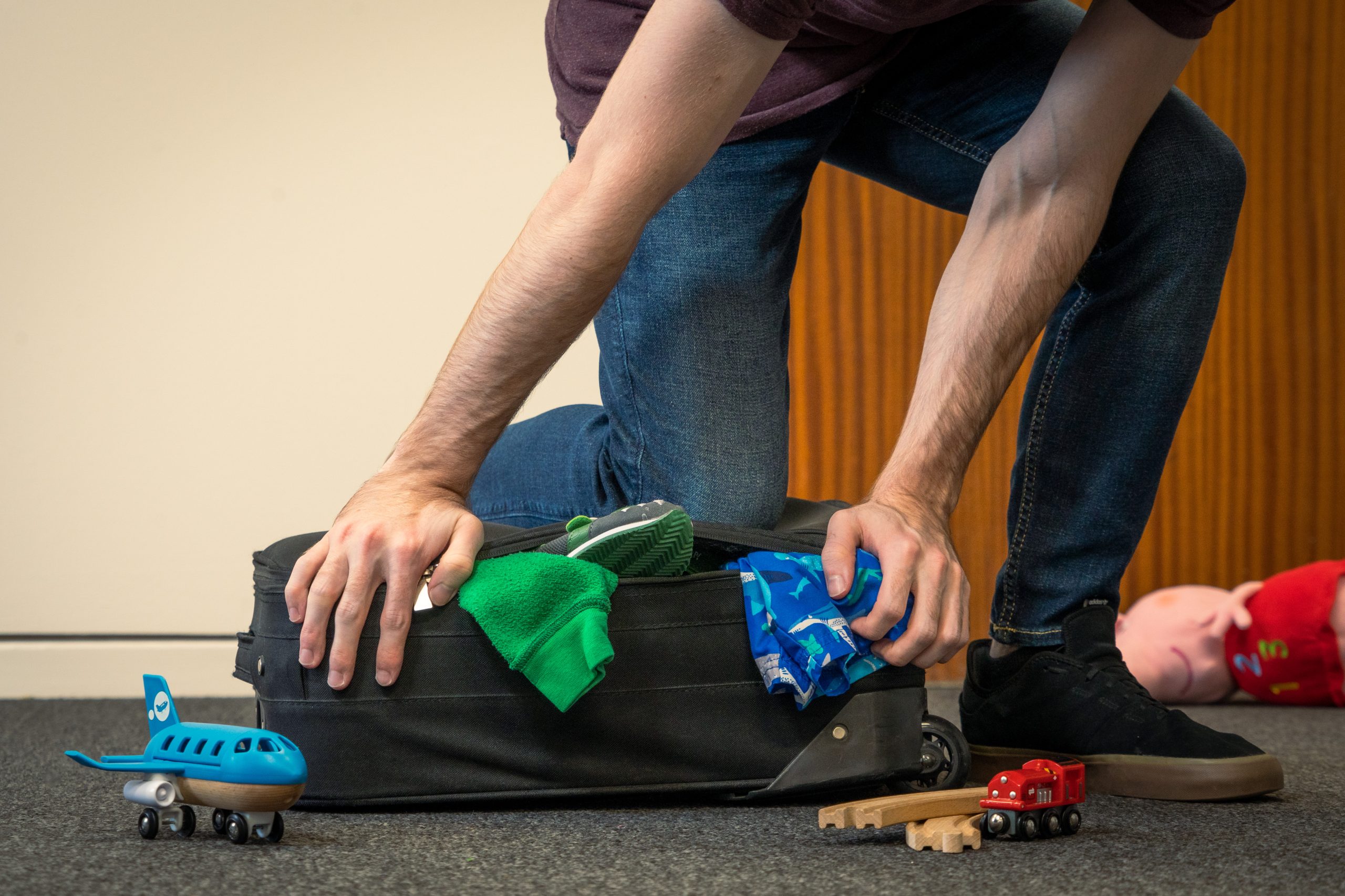 Beach vacation packing list photo of a family packing a suitcase together