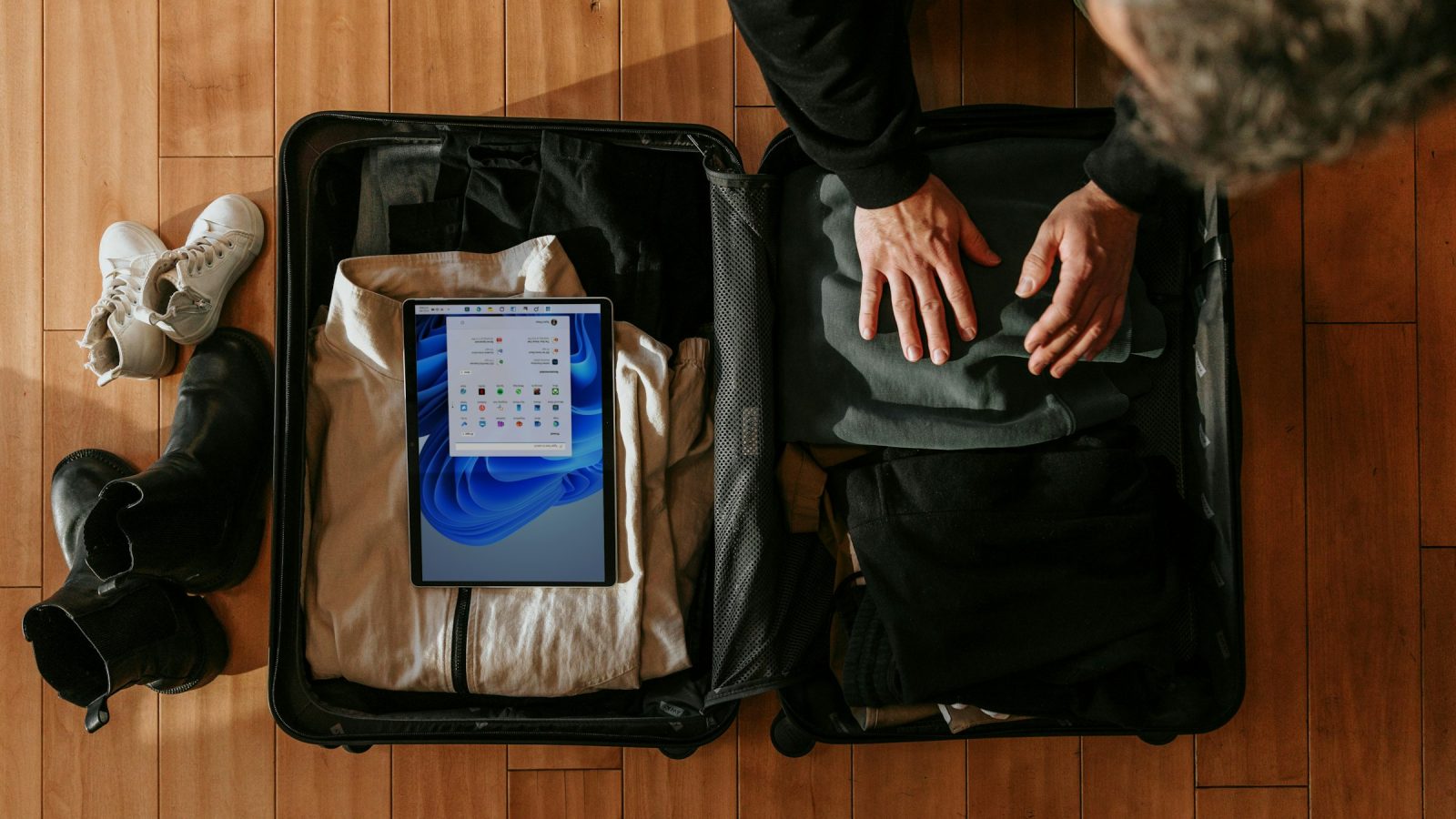 Carry-on packing tips in action: overhead view of a traveler packing a suitcase