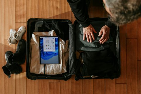 Carry-on packing tips in action: overhead view of a traveler packing a suitcase