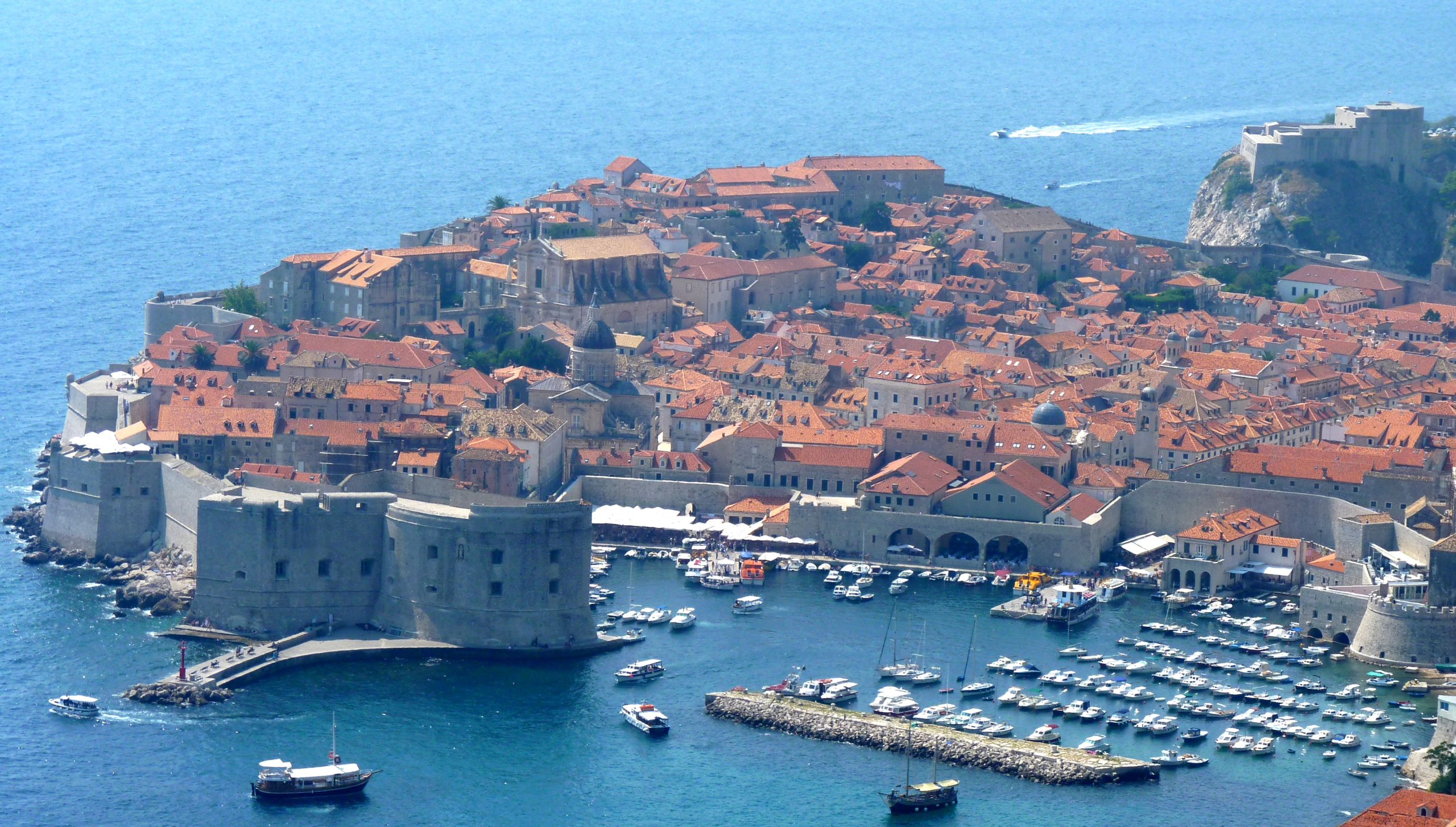 Panoramic rooftop view of Dubrovnik Old Town's red-tiled roofs and the Adriatic Sea