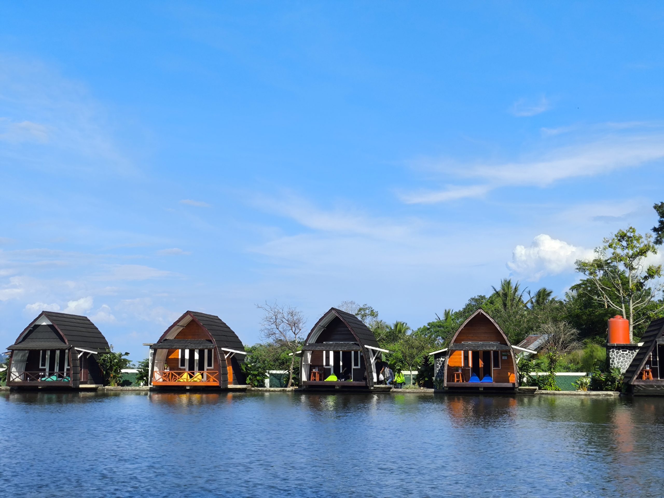 Glamping resort grounds with furnished tents and outdoor seating areas