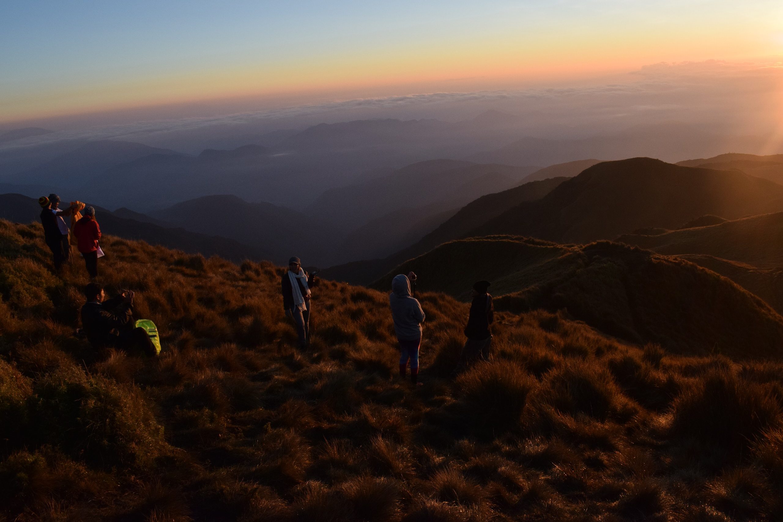 Hikers watching the sunrise from a mountain summit