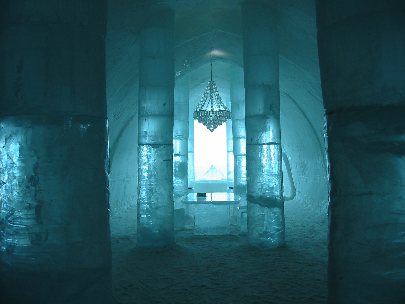 Carved ice hotel suite in Scandinavia with sculpted ice furniture and reindeer hides