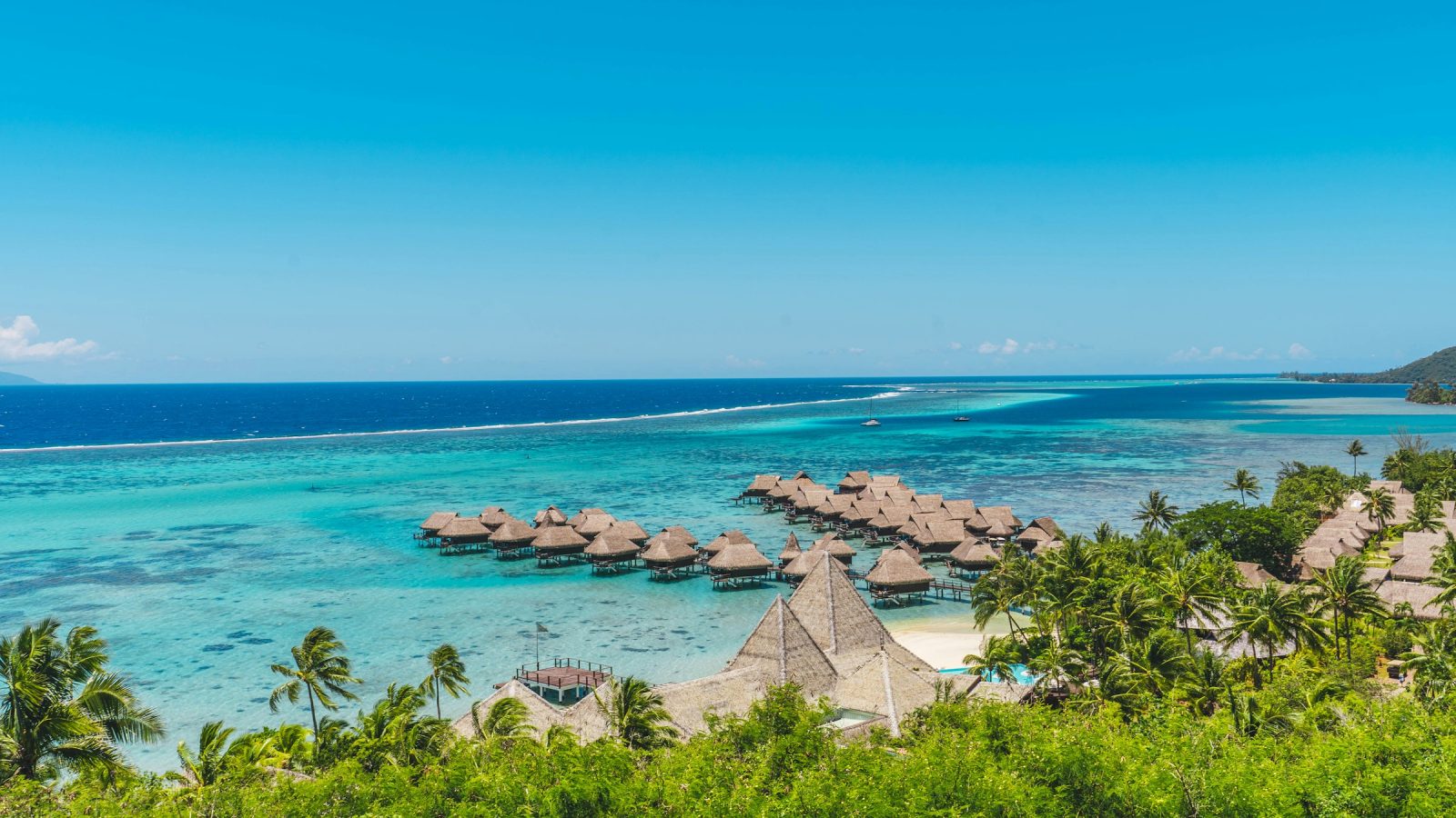Overwater bungalow resorts over turquoise lagoon water in Moorea