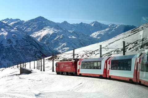 Glacier Express train winding through the Swiss Alps, an icon of slow train travel in Europe
