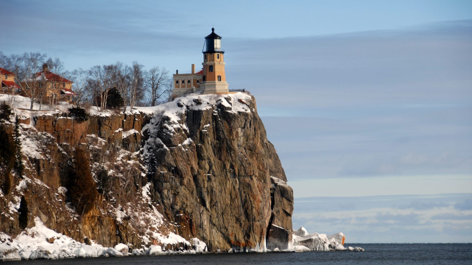 A historic lighthouse hotel-style tower perched on a cliff above Lake Superior